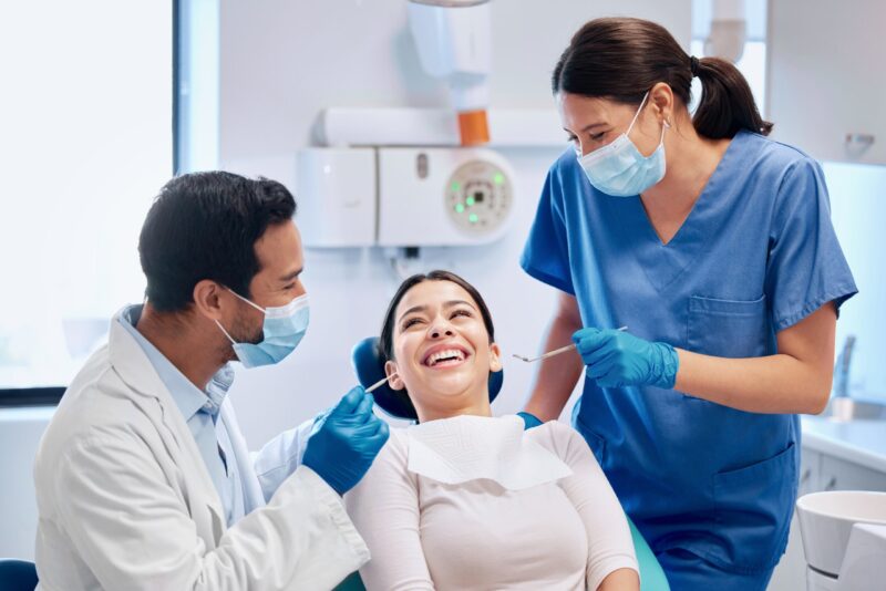 Dentist and dental assistant examining a patient