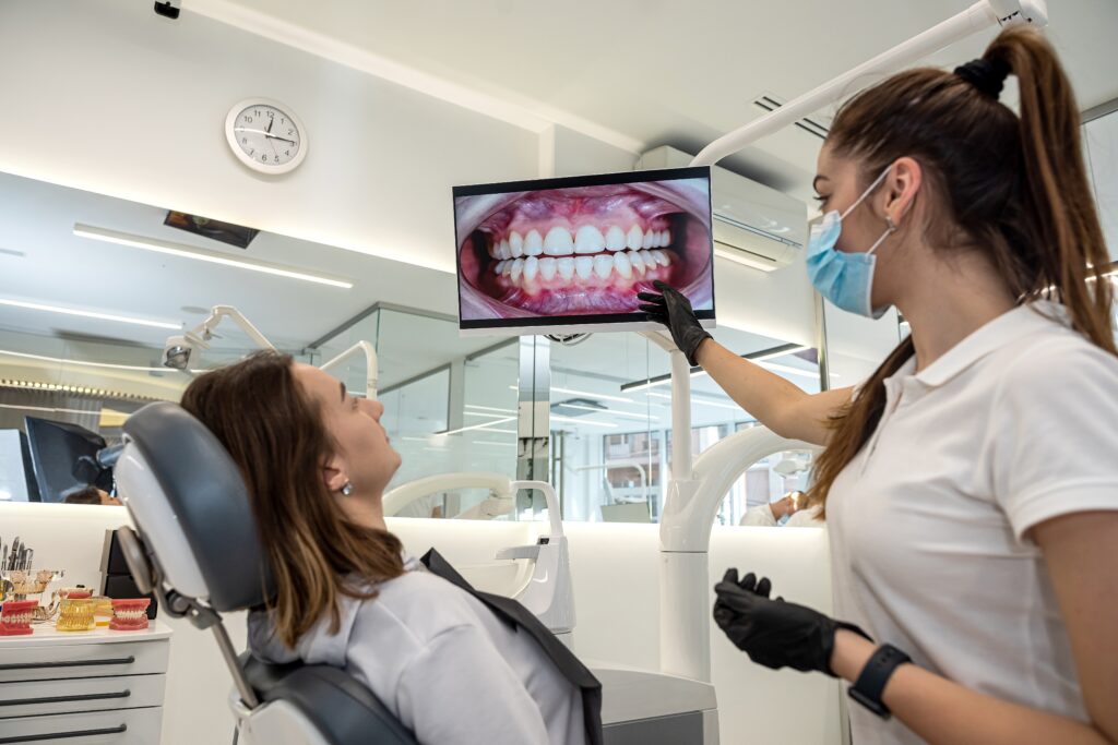Dentist reviewing dental X-rays with a patient during an examination