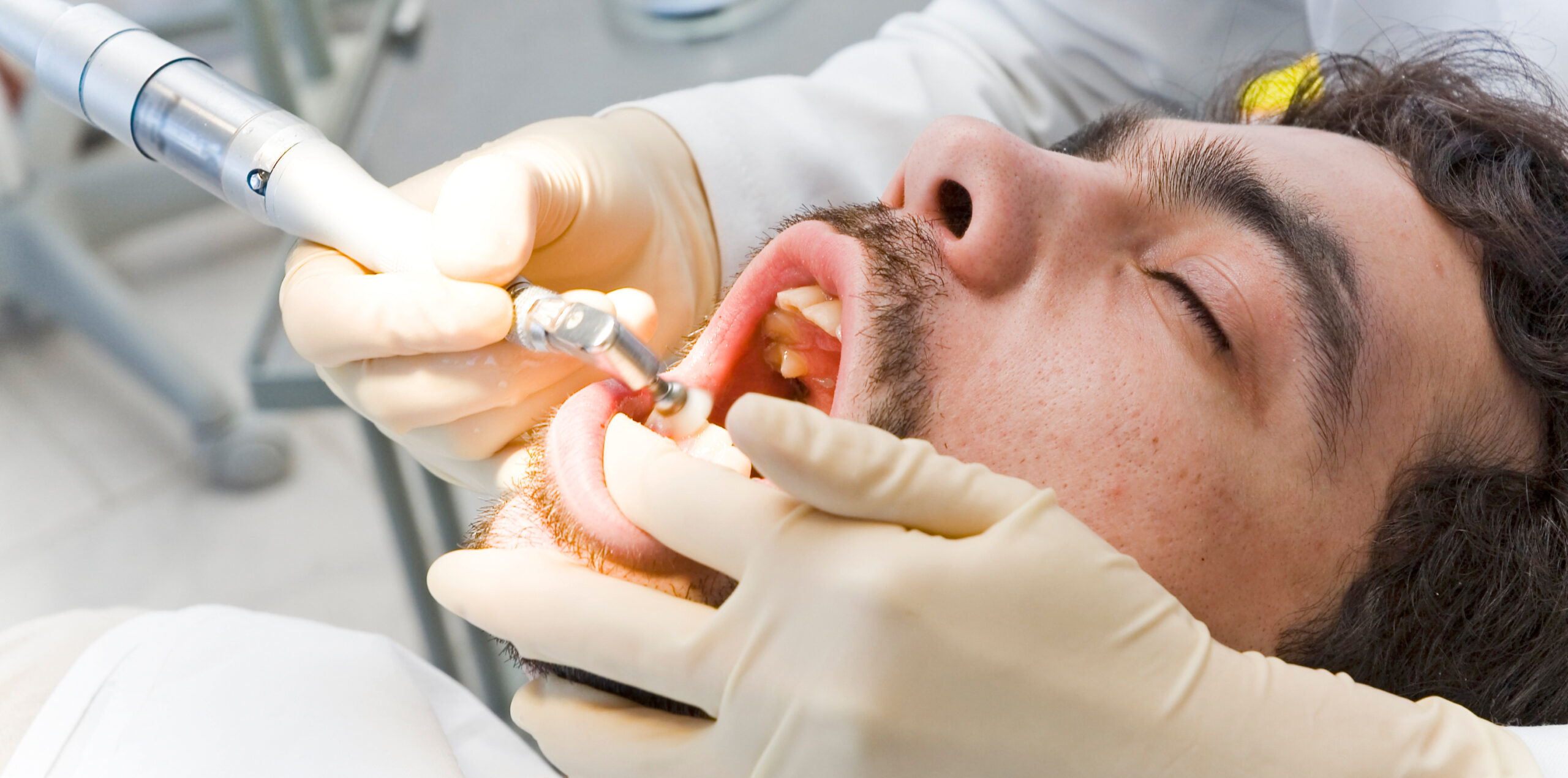 Dentist examining a patient’s teeth with dental instruments